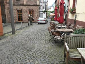 摩泽尔河畔的泽尔Weingut Day的一条鹅卵石街道,上面有桌椅和一辆汽车