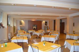 斯波莱托卡萨•瑞丽吉奥萨•迪•欧斯匹塔利塔•纳扎雷诺酒店的餐厅设有桌椅和黄色桌布