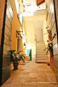 梅纳焦Casa Azzurra的楼里一条有楼梯和盆栽的小巷