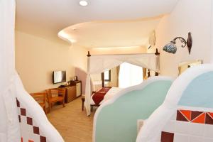 鹅銮鼻磐石旅店的一间带两张床和电视的卧室