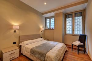 都灵马特奥迪25号酒店的一间卧室配有一张床、一把椅子和窗户。