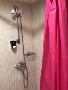 科斯镇雅尼斯开普敦公寓的浴室里配有带粉红色连衣裙的淋浴