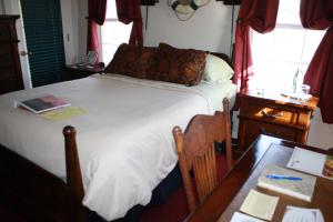 拉伯克伍德罗住宿加早餐旅馆的一间卧室配有一张床和一张带桌子的木桌。