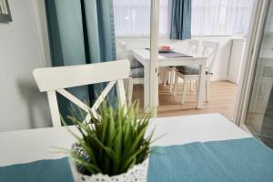 奥斯赛拜-塞林MyHome Ruegen - Haus Arkona的一间设有白色桌子和白色椅子的用餐室
