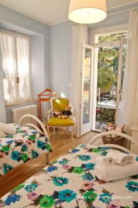 梅纳焦Casa Azzurra的一间卧室配有两张床和一张黄色椅子