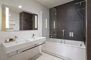 利贝雷茨Apartmány Terasy Café的白色的浴室设有水槽、浴缸和镜子