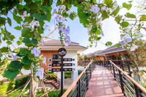 黎府普鲁阿奇瑞度假酒店的通往紫色花卉度假村入口的走道