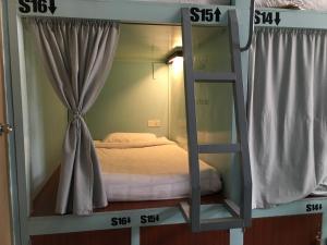娘瑞旅游之歌旅舍的带2扇窗户的客房内的双层床
