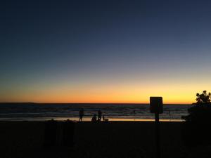 帕克德尔柏岱尔汽车旅馆的一群人日落时在海滩上散步