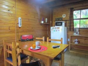 凡塔纳镇Cabañas Ñuke Mapu的厨房配有木桌和冰箱。