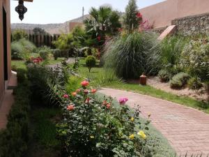 阿加迪尔Riad Asmaa Agadir的砖路上种有鲜花和植物的花园