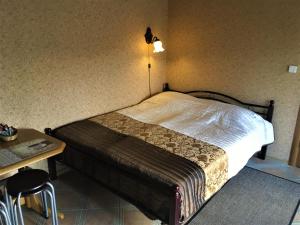 文茨皮尔斯海边度假屋的一间卧室配有一张床、一张桌子和一盏灯