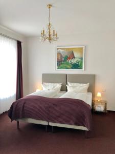 韦斯特兰叙尔特岛布劳姆谢酒店的一间卧室配有一张带吊灯的大床