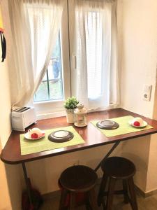 里斯本Lisbon Secret & Graca Apartment的一个带两个盘子和两个凳子的厨房台