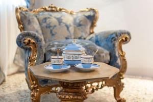 威尼斯San Marco Luxury apartments Muneghe的桌子上放着两个杯子,茶壶