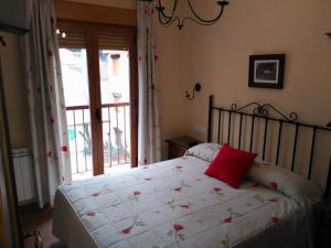 阿罗约弗里奥瓜达尔基维尔山谷公寓的一间卧室配有一张红色枕头的床