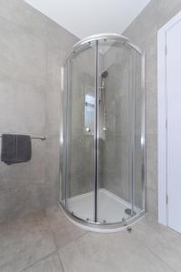 浦耳Sandbanks Road的浴室里设有玻璃门淋浴