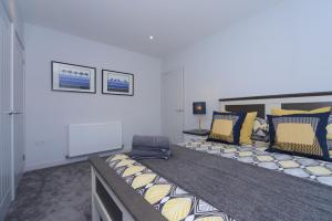 浦耳Sandbanks Road的一间卧室配有一张大床,提供黄色和蓝色的枕头