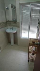 马塔拉斯卡尼亚斯塔玛琳多旅馆的一间带水槽的浴室和一个带百叶窗的窗户