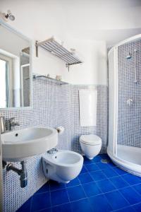 文托泰内尤利亚别墅酒店的蓝色瓷砖浴室设有水槽和卫生间