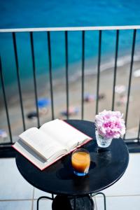 文托泰内尤利亚别墅酒店的一张桌子,上面放着一本书,还有蜡烛和鲜花
