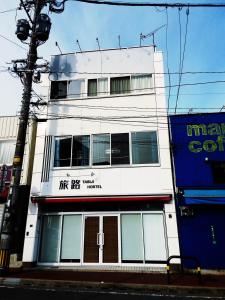 福冈Fukuoka Tabiji Hostel & Guesthouse的街道边的白色建筑