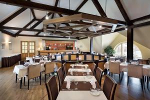 撒加迪萨伽迪庄园酒店的一间带桌椅的用餐室,位于带天花板的房间内