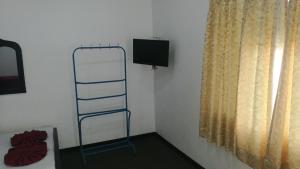 KilinochchiFriends Paradise的一间设有梯子、电视和窗户的房间