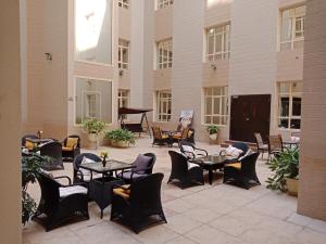 多哈公园酒店的一个带桌椅和钢琴的庭院