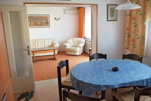 乌马格Apartments & Rooms BARBARA的客厅配有蓝色的桌子和椅子