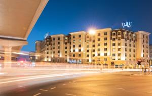 迪拜Avani Deira Dubai Hotel的城市街道,晚上有建筑