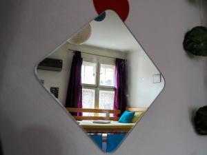 贝尔格莱德埃尔迪亚布勒旅舍的一间卧室设有窗户和一张带紫色窗帘的床
