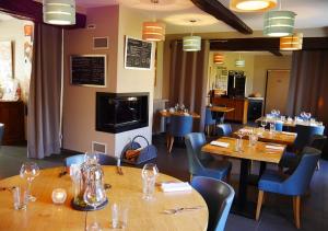 蒂龙加尔代Logis - Auberge de l'Abbaye的餐厅设有木桌和蓝色椅子