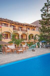 卡马利圣埃伦娜酒店的一座带游泳池的度假村,位于一座建筑前