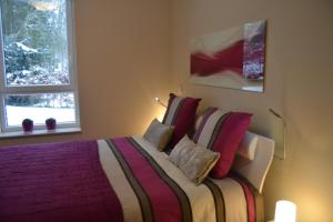 维尔雅尔姆la terrasse du lac的一间卧室配有一张带红色枕头的大床