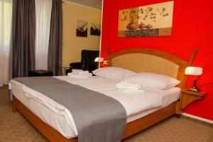 菲尔德施塔特Aristo Hotel的一间卧室设有一张红色墙壁的大床