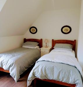 亚达尔The Hollies的一间卧室设有两张床和床头柜