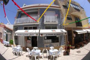 普拉亚德米拉GuestHouse O Cuco的大楼前设有桌椅的餐厅