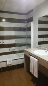 梅里达罗梅罗梅里达酒店的一间带玻璃淋浴和水槽的浴室
