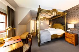 罗滕堡伯格酒店的酒店客房设有一张大床和一张书桌。