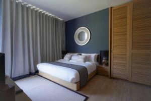 迈考海滩Baan Mai Khao的卧室配有一张床,墙上设有镜子