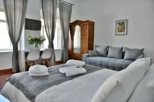 伊兹拉Douskos Port House的卧室配有一张白色的大床和一张沙发。