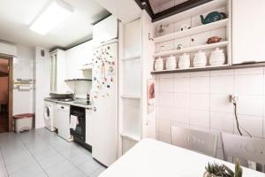 马德里Vivienda Familiar con Jardin junto a Ifema的厨房配有白色冰箱和炉灶。