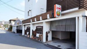 大分Hotel Pal Oita (Love Hotel)的街道上带有 ⁇ 红标志的建筑物