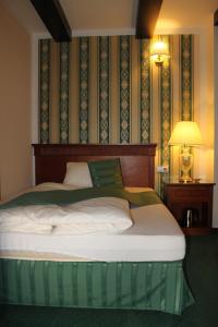 卡丹U卡拉IV旅馆。的一间卧室配有一张带绿色和白色毯子的床