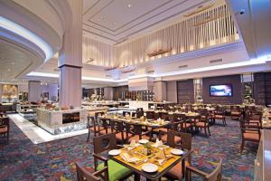 曼谷Rama Gardens Hotel Bangkok - SHA Plus Certified的一间带桌椅和壁炉的餐厅