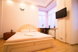 莫斯科特维尔大街豪华公寓的一间卧室配有一张床和一台平面电视