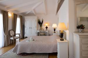雷夫卡达镇博斯查特酒店的白色卧室配有床和桌子