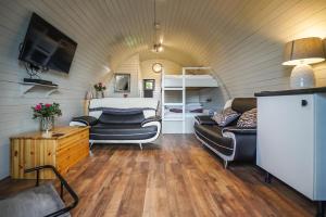 弗罗德舍姆Deluxe Glamping Pod with Hot Tub的客厅配有沙发和一张位于房间的床