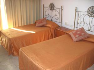 多列毛利诺斯CASTILLO DE SANTA CLARA 2的两张带橙色床单的床